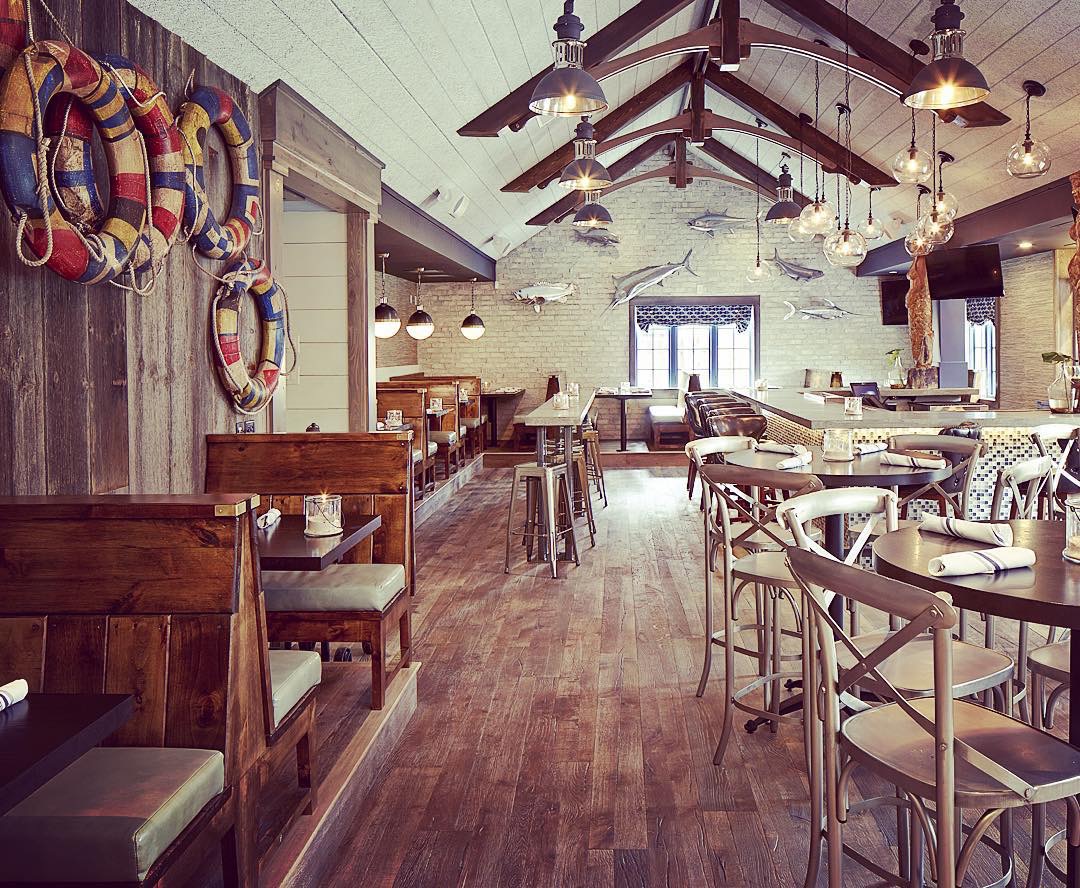 Completed restaurant bar beneath timber trusses and pendant lighting