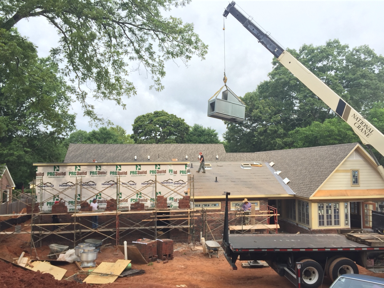 Commercial rooftop equipment being set by crane during restaurant construction