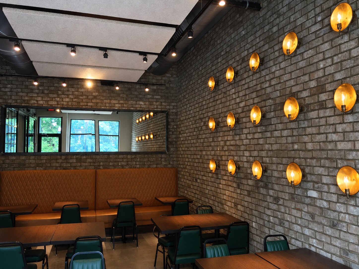 Completed Coalition dining room with illuminated brick wall and tailored banquettes