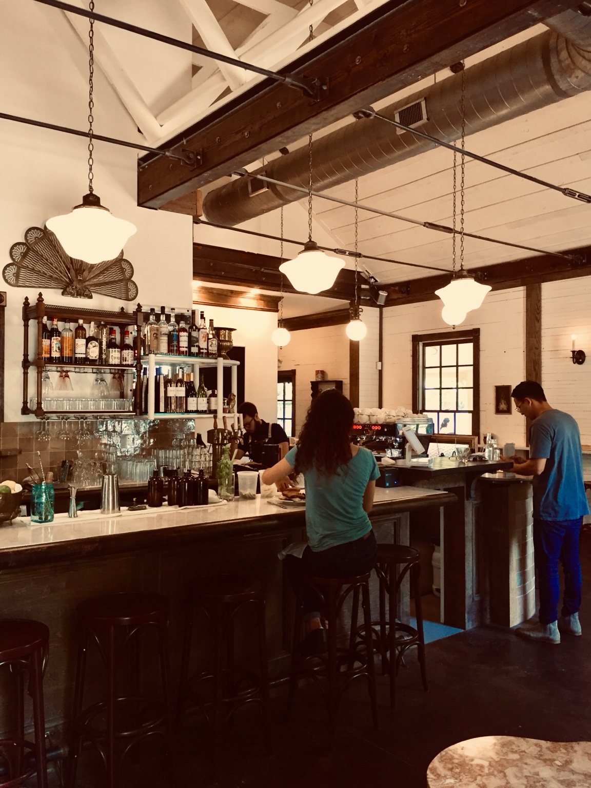 Fellows bar framed by dark timber beams and suspended pendant lights