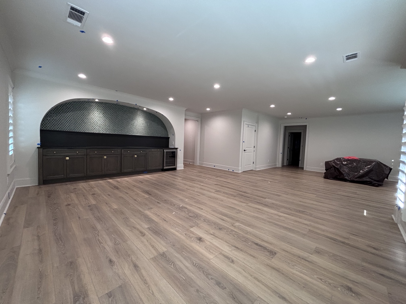 Completed terrace-level entertaining room with an arched built-in bar