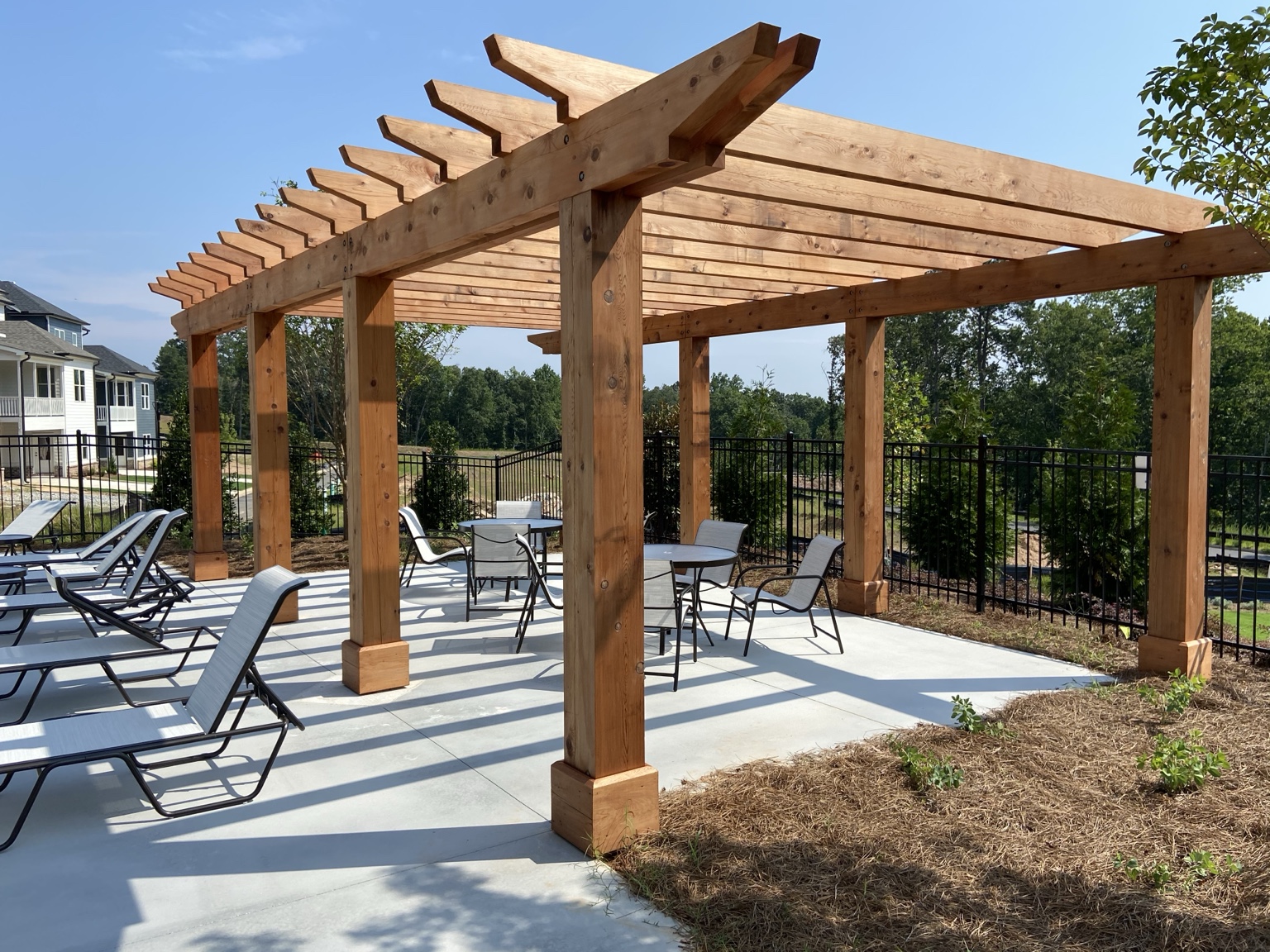 Timber pergola and seating area beside the Inwood neighborhood pool