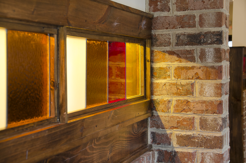 Stained glass, wood trim, and reclaimed-style brick detail at Osteria Mattone
