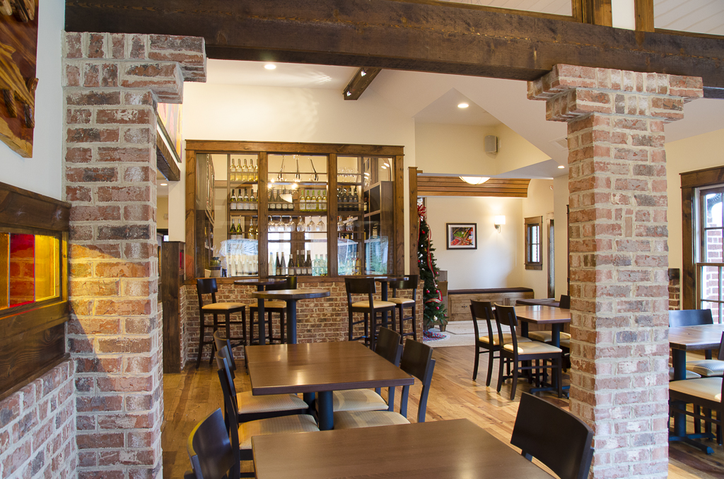Osteria Mattone dining room framed by brick piers and heavy timber