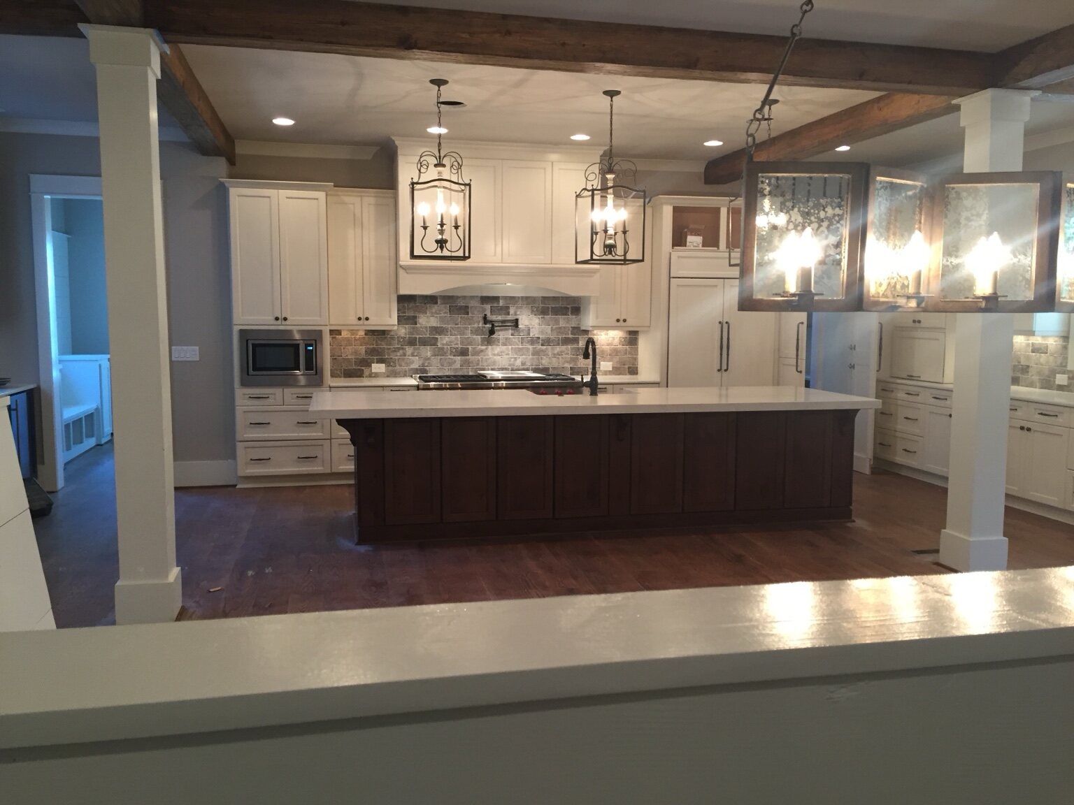 Large custom kitchen framed by stained timber beams