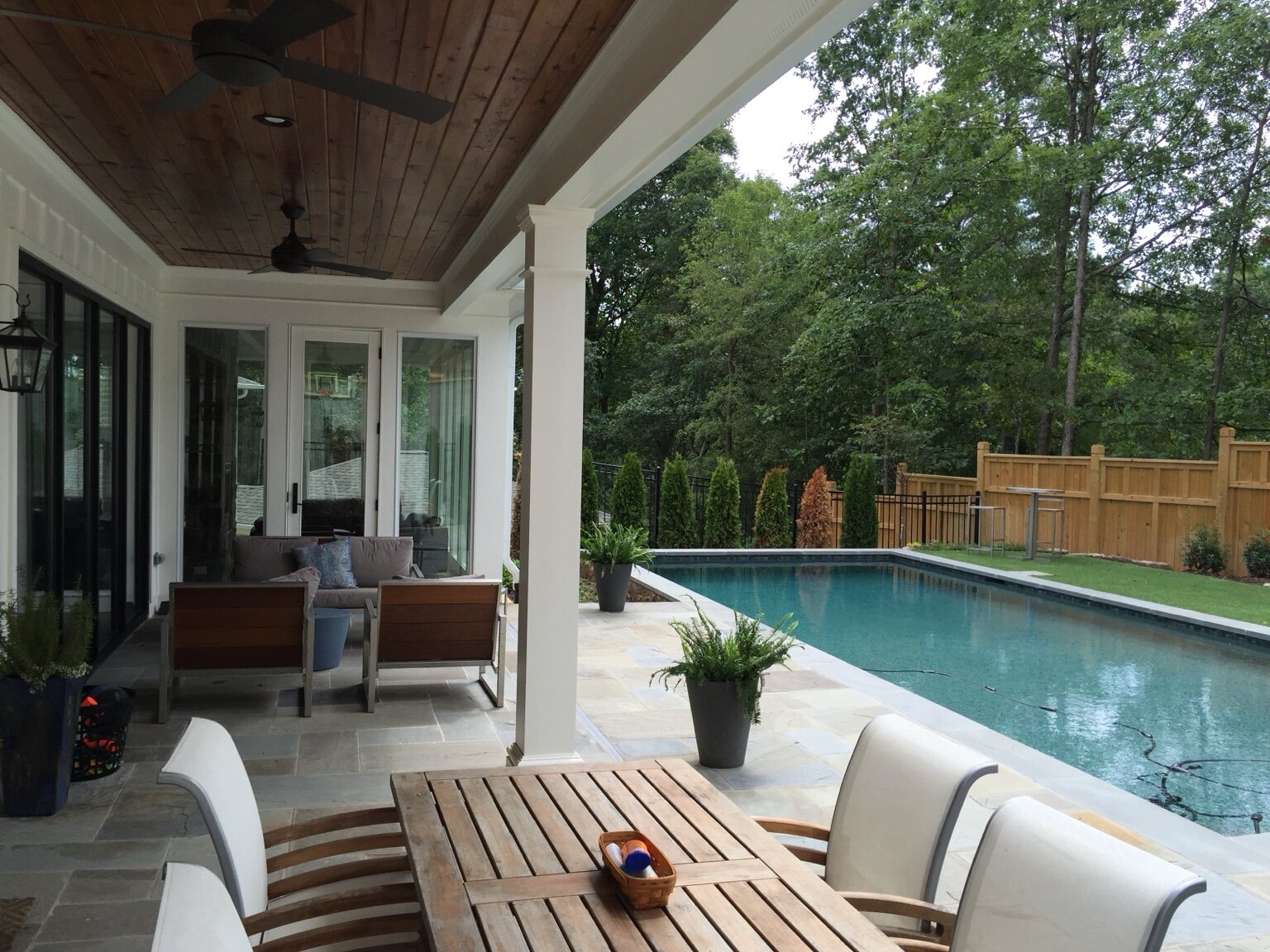 Covered outdoor living area overlooking a private pool