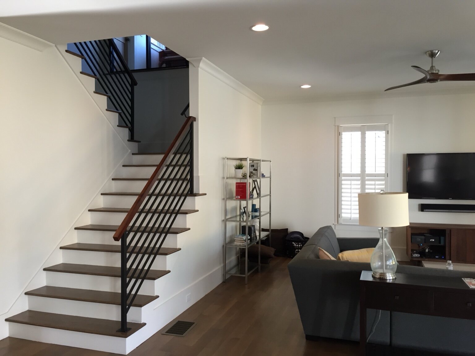 Open residential stair with dark wood treads and slender metal railings