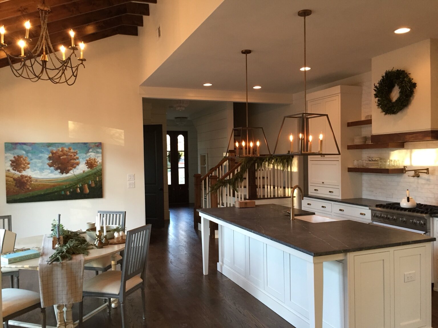 White custom kitchen with dark stone counters and floating wood shelves