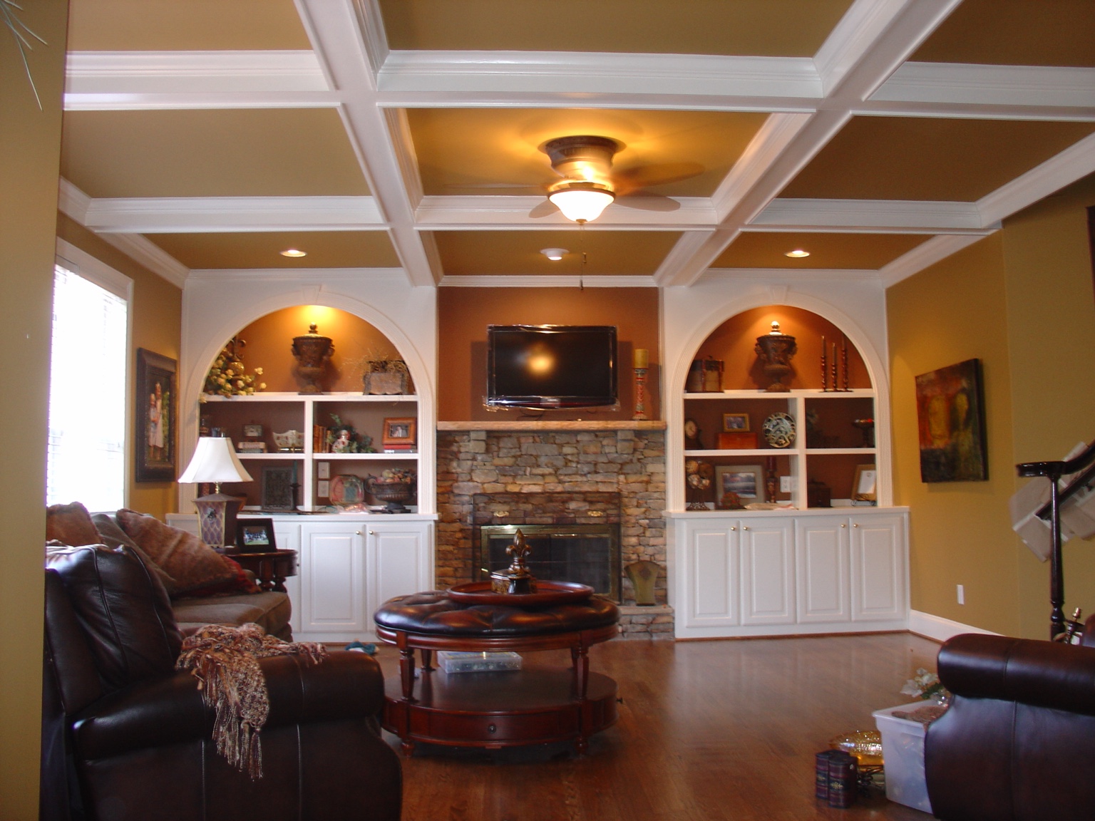 Finished recreation room with coffered ceiling, fireplace, and built-ins