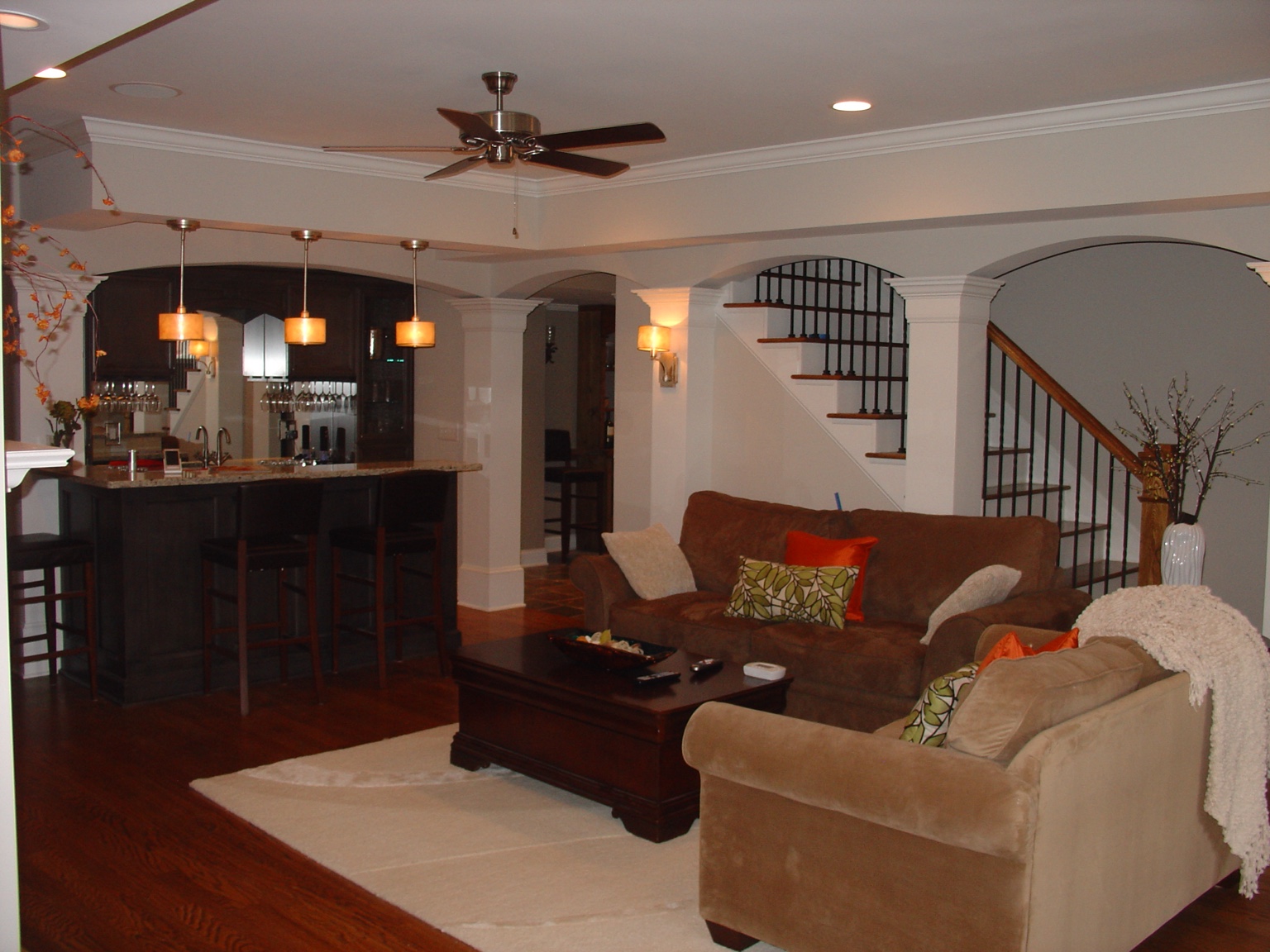 Renovated lower-level family room with bar and arched openings