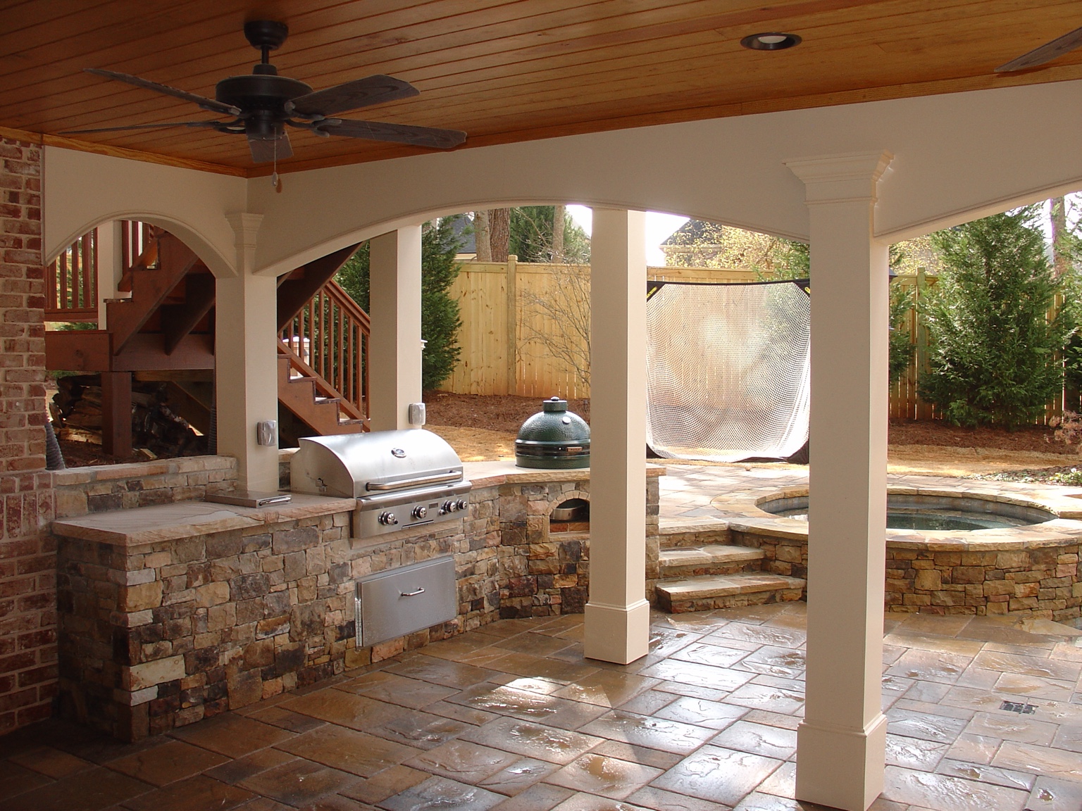 Covered outdoor kitchen and living space beside a pool